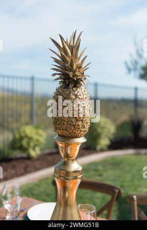 Ananas d'oro su una colonna d'oro su un tavolo a tema tropicale Foto Stock