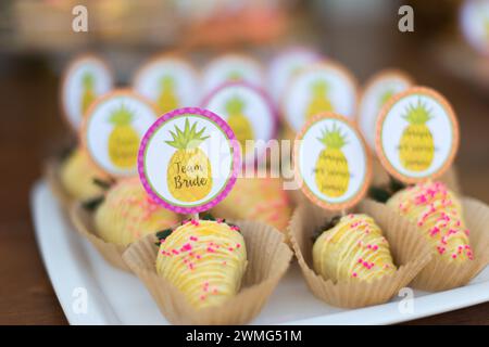 Fragole ricoperte di cioccolato come ananas su un tavolo di legno Foto Stock