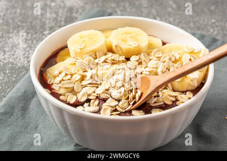 Un primo piano di acai brasiliani con fette di banana e farinata d'avena Foto Stock