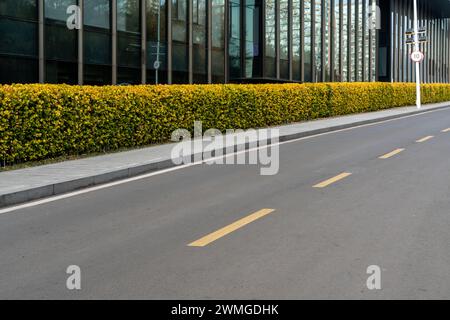 Una strada asfaltata vuota nel centro della città moderna durante il giorno Foto Stock