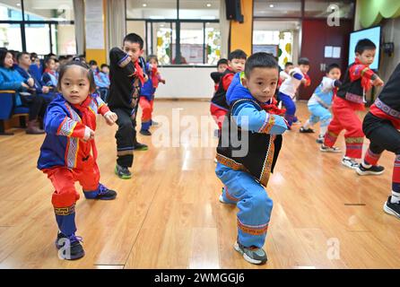 Pechino, la regione autonoma cinese Guangxi Zhuang. 26 febbraio 2024. Gli studenti si esibiscono nelle arti marziali del gruppo etnico Zhuang durante una cerimonia che segna l'inizio del nuovo semestre presso la Baihualing Road Primary School di Nanning, nella regione autonoma di Guangxi Zhuang, Cina meridionale, 26 febbraio 2024. Il nuovo semestre per le scuole primarie e secondarie è iniziato lunedì in molte parti della Cina. Crediti: Zhou Hua/Xinhua/Alamy Live News Foto Stock