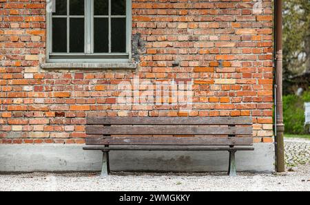 Eine Sitzbank im hinteren Bereich der Baracke X, dem Krematoriumsgebäude. In der Umgebung wurden auch Morde an Gefangenen verübt, da der Bereich abgel Foto Stock