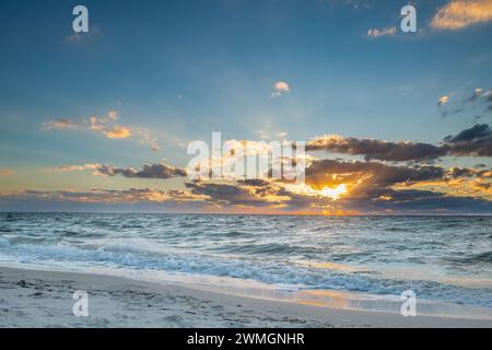 Splendido paesaggio nuvoloso al tramonto su onde limpide Foto Stock
