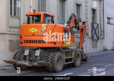 Nancy, Francia - escavatore gommato arancione Liebherr A 910 Compact Litronic parcheggiato in una strada. Foto Stock