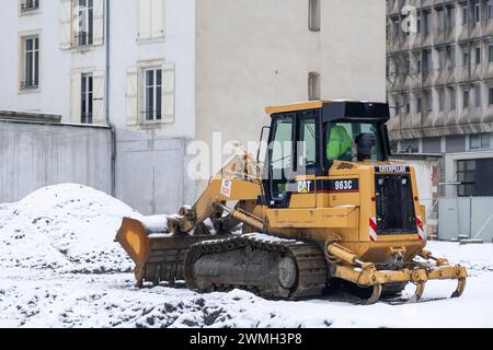 Nancy, Francia - pala cingolata gialla CAT 963C per lavori di terra in cantiere sotto la neve. Foto Stock