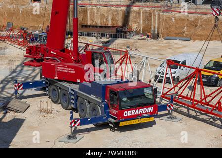 Nancy, Francia - gru mobile rossa e blu Liebherr LTM 1100-4.2 in un cantiere per il montaggio di una gru a torre. Foto Stock