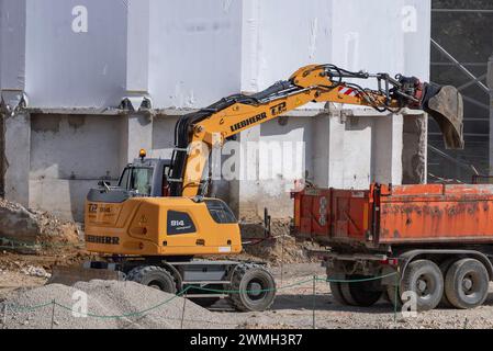 Nancy, Francia - informazioni su un escavatore gommato giallo Liebherr A 914 Compact caricamento di un autocarro per lavori di terra in cantiere. Foto Stock