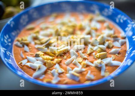 Tradizionale zuppa andalusa di salmorejo guarnita con uova sode tritate, servita fredda. Foto Stock