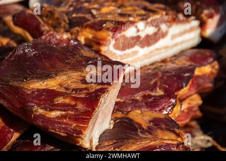 Pancetta esposta e carne secca prodotti domestici presentati per la vendita sul mercato agricolo del villaggio di Kacarevo, pancetta da gastronomia e prodotti a base di carne secca Foto Stock