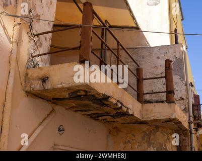 Balcone che necessita di lavori di ristrutturazione e che rischia di crollare su una casa dallo stile architettonico del sud Foto Stock