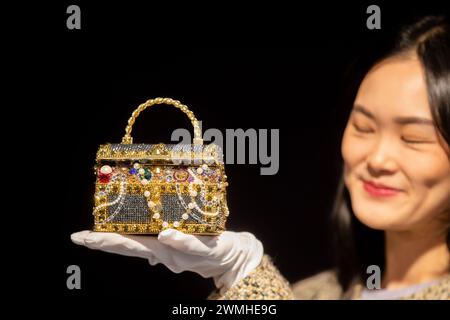 Londra, Regno Unito. 26 febbraio 2024. Un membro dello staff possiede una pochette Gold "Sunken Treasure Chest" di Judith Leiber (valore stimato £ 600-£ 800) che fa parte dei saldi Bonhams Designer Handbags and Fashion il 28 febbraio 2024 - Bonhams Knightsbridge, Londra, Inghilterra. (Credit Image: © Tayfun Salci/ZUMA Press Wire) SOLO PER USO EDITORIALE! Non per USO commerciale! Foto Stock