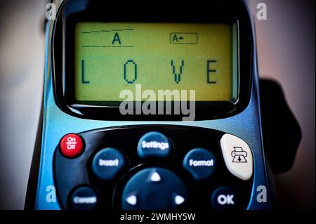 Etichettatrice che mostra la parola amore sul suo schermo, simboleggia un'espressione moderna e tecnologica dell'amore. Foto Stock