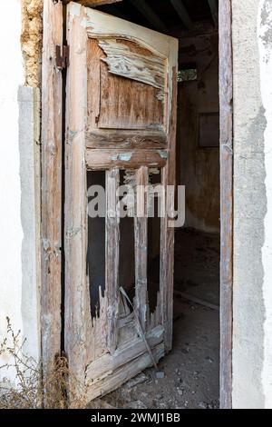 Vecchie porte in legno demolite che conducono ad un edificio infestato in al Jazirah al Hamra, città abbandonata a Ras al Khaimah, Emirati Arabi Uniti Foto Stock