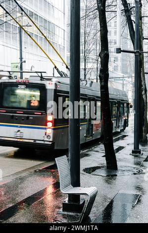 Un troller rallenta prima di fermarsi alla fermata successiva di Granville Street, passando davanti a una sedia fissata sul marciapiede. Foto Stock