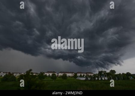 Una grande nuvola oscura e minacciosa incombe sul paesaggio urbano Foto Stock