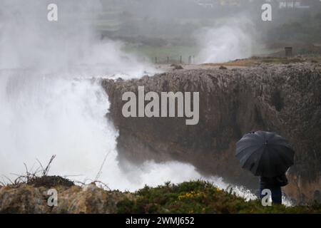 Cuerres, Spagna, 26 febbraio 2024: Una persona guarda come l'olejae supera le scogliere durante l'allarme Naranka Wave a causa della tempesta Monica, il 26 febbraio 2024, a Cuerres, Spagna. Crediti: Alberto Brevers / Alamy Live News. Foto Stock