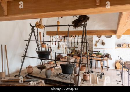 Antica cucina del castello con calderoni appesi ed erbe aromatiche. Foto Stock