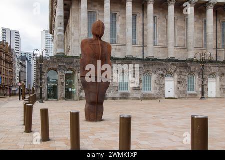 L'uomo di ferro. La statua è stata reintegrata in un nuovo luogo nel 2022 e trasferita dopo i lavori per installare un nuovo sistema di tram in Victoria Square. Iron:Man è una statua di Antony Gormley, in Victoria Square, Birmingham, Inghilterra. La statua è alta 6 metri (20 piedi), compresi i piedi che sono sepolti sotto il marciapiede, e pesa 6 tonnellate metriche (6 tonnellate lunghe). La statua si inclina di 7,5° all'indietro e di 5° alla sua sinistra.[1] si dice che lo scultore rappresenti le abilità tradizionali di Birmingham e della Black Country praticate durante la Rivoluzione industriale. Il municipio di Birmingham può essere visto Foto Stock