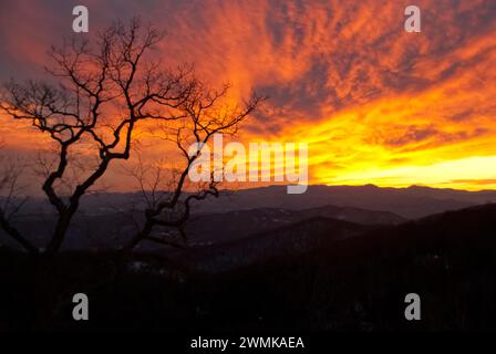 Il tramonto illumina le nuvole con una luce arancione Foto Stock