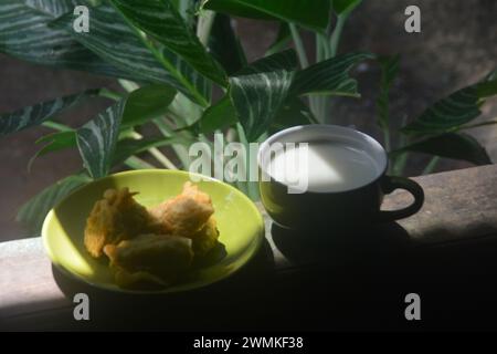 vista ravvicinata delle banane fritte e del caffè caldo. banane fritte accompagnate da caffè caldo la mattina sulla terrazza della casa. Un'abitudine fatta da Ind Foto Stock