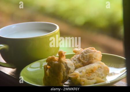 vista ravvicinata delle banane fritte e del caffè caldo. banane fritte accompagnate da caffè caldo la mattina sulla terrazza della casa. Un'abitudine fatta da Ind Foto Stock