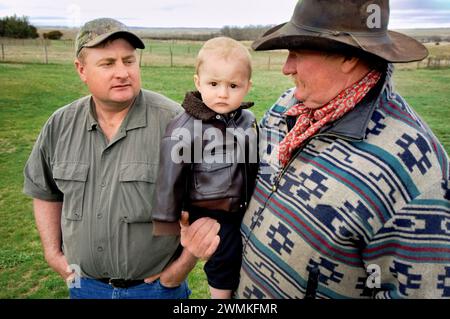 Tre generazioni, un padre, un figlio e un nipote trascorrono del tempo insieme in un ranch; Gibbon, Nebraska, Stati Uniti d'America Foto Stock