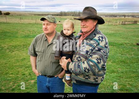 Tre generazioni, un padre, un figlio e un nipote trascorrono del tempo insieme in un ranch; Gibbon, Nebraska, Stati Uniti d'America Foto Stock