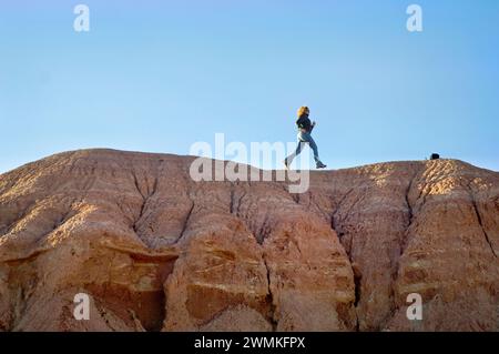 Woman corre attraverso un affioramento roccioso in un ranch; Santa Fe, New Mexico, Stati Uniti d'America Foto Stock