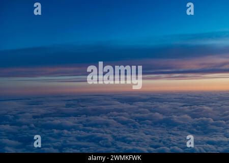 Splendida vista aerea sopra le nuvole soffici con un cielo pastello al crepuscolo, volo da Terrace a Vancouver; British Columbia, Canada Foto Stock