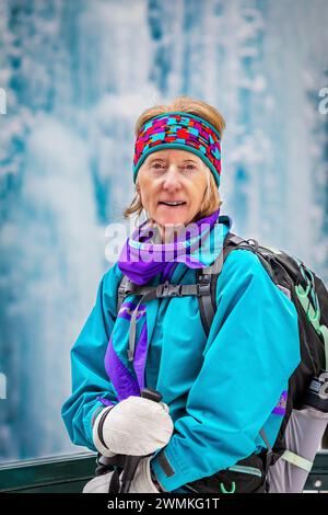 Ritratto di una donna escursionista in inverno con un ghiaccio ghiacciato sullo sfondo; Lake Louise, Alberta, Canada Foto Stock