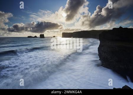 Vista panoramica della costa dell'isola Dyrholaey con le onde e le scogliere frastagliate, vicino a Vik, nell'Islanda meridionale; Dyrholaey Island, Islanda Foto Stock