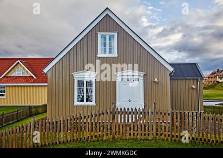 Pittoresca casa con facciata marrone, dettagli architettonici bianchi e una recinzione a picchetto in legno; Stykkisholmur, penisola di Snaefellsnes, Islanda Foto Stock