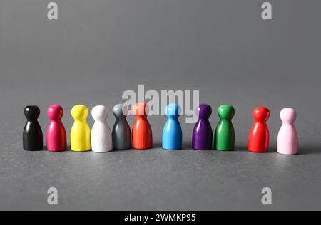 Fila di figure umane colorate su sfondo grigio. Concetto di inclusione Foto Stock