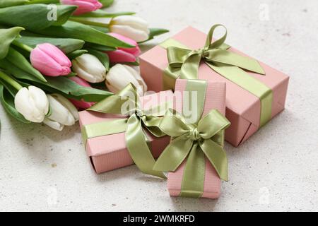 Confezioni regalo e bouquet di splendidi tulipani su sfondo bianco. Giornata internazionale della donna Foto Stock