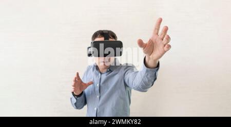 Uomo d'affari che utilizza occhiali per realtà virtuale in ufficio. Visore Man in VR in piedi per toccare gli oggetti nella simulazione digitale. Visualizzazione 3D realistica, poll Foto Stock