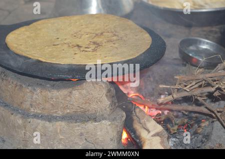 Preparazione di roti (Chapati indiani) su roti tawa di grano con la mano Foto Stock