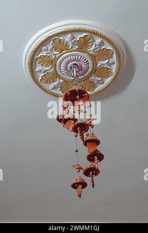 Vista della decorazione circolare floreale sul tetto e delle campane rosse in terra appese al gancio Foto Stock