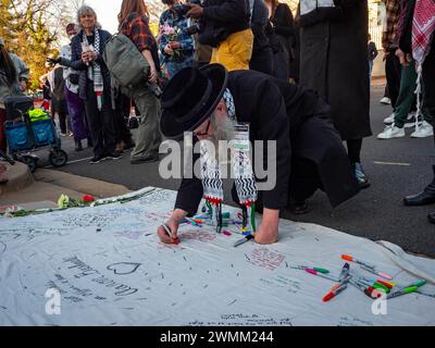 Washington, District of Columbia, USA. 26 febbraio 2024. Un membro della setta Naturei Karta International scrive un messaggio per onorare la memoria di Aaron Bushnell, che si è dato fuoco per protestare contro gli attacchi di IsraelÃs contro la popolazione di Gaza. (Credit Image: © sue Dorfman/ZUMA Press Wire) SOLO PER USO EDITORIALE! Non per USO commerciale! Crediti: ZUMA Press, Inc./Alamy Live News Foto Stock