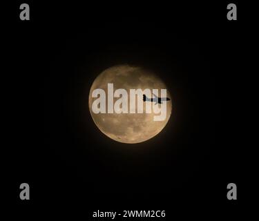 Volo commerciale di linea di fronte alla Luna piena di notte (3 di 3) Foto Stock