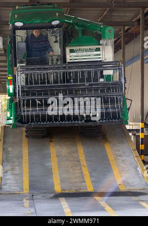 TAIZHOU, CINA - 27 FEBBRAIO 2024 - i lavoratori effettuano una prova di arrampicata di una mietitrice prima che lasci la fabbrica di Taizhou, provincia di Jiangsu, Cina Foto Stock