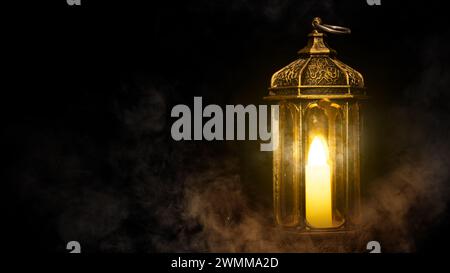 Lanterna araba ornamentale con candela accesa illuminata da uno sfondo scuro. Concetto Ramadan Foto Stock