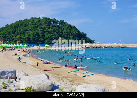 Contea di Yangyang, Corea del Sud - 30 luglio 2019: La tranquilla montagna di Jukdo, con il suo osservatorio che si affaccia, fa da sfondo pittoresco per i surfisti Foto Stock
