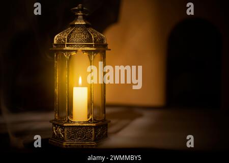 Lanterna araba ornamentale con candela accesa illuminata da uno sfondo scuro. Concetto Ramadan Foto Stock
