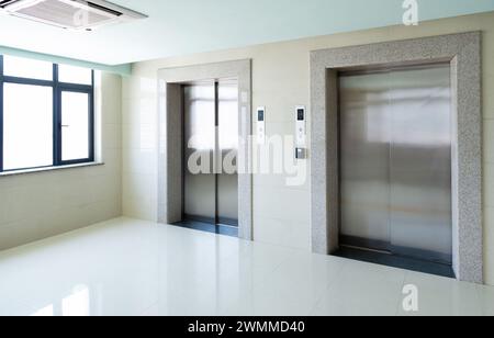 Moderne cabine con ascensore in acciaio nella hall business Foto Stock