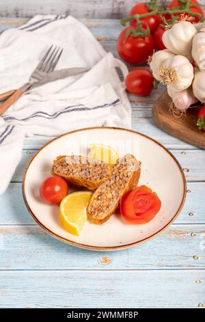 Polpette Kadinbudu. Antipasti. Polpette turche tradizionali su sfondo blu in legno. nome locale kadınbudu köfte Foto Stock