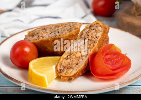 Polpette Kadinbudu. Antipasti. Polpette turche tradizionali su sfondo blu in legno. nome locale kadınbudu köfte. Primo piano Foto Stock