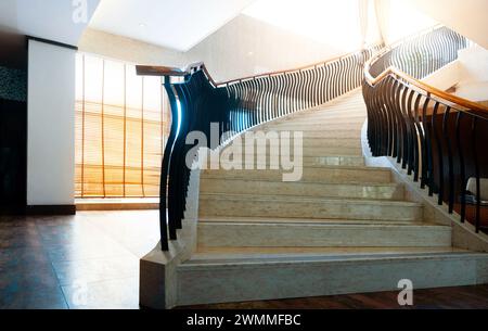 Scale in marmo e banisteri neri in un edificio moderno Foto Stock