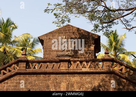 Old Goa, India - 19 dicembre 2022: L'Arco del Viceré con una statua di San Catherine tiene una spada in una e un libro aperto nell'altra. Foto Stock
