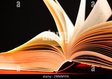 Le pagine di un libro spesso vengono attivate su uno sfondo nero. Foto Stock