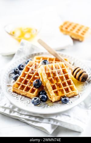 Waffle dolci e molto gustosi con miele e mirtilli. Foto Stock